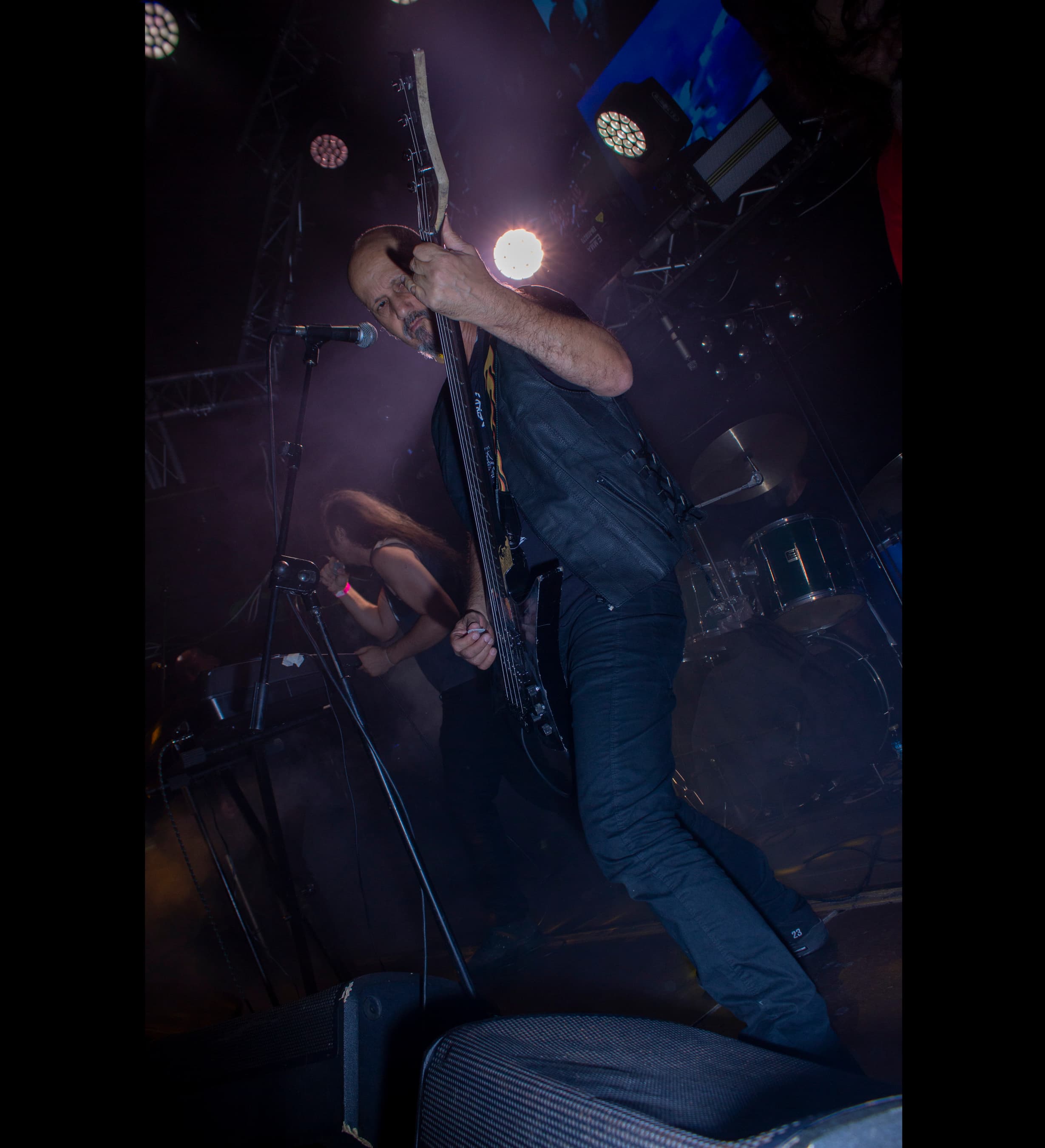 Concert camera angle capturing musicians under dramatic stage lights